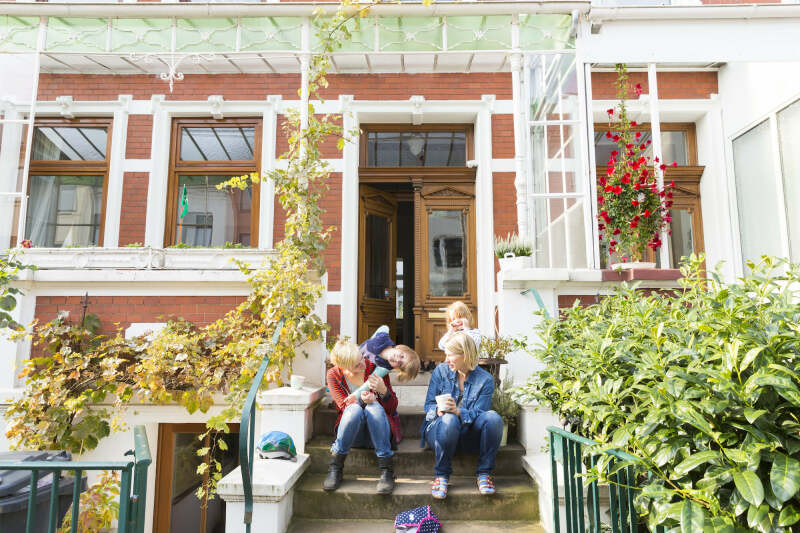 Eine Familie sitzt auf der Treppe vor einem Bremer Haus
