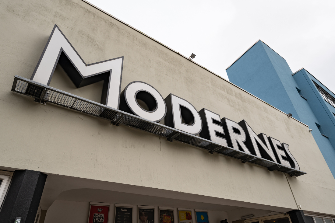 Außenansicht eines hellen, eckigen Gebäudes mit dem Schriftzug "Modernes".