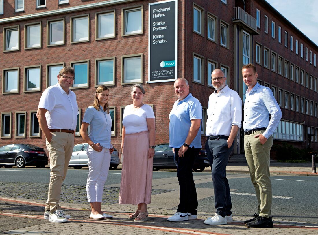 6 Personen der Lenkungsrunde der Klimakooperation Fischereihafen stehen vor einem roten Backsteingebäude mit Logo der CCF.